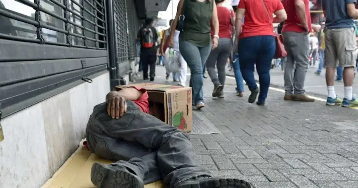 Pessoa desabrigada dormindo na rua durante o dia.