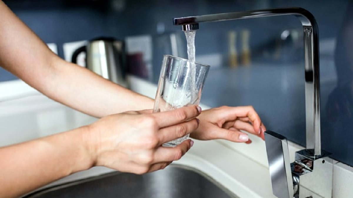 Encher copo de água na torneira moderna.