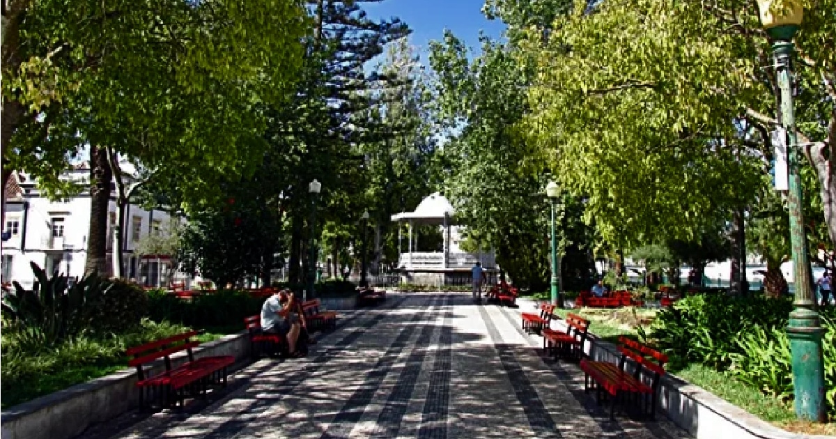 Jardim sombreado com bancos e coreto em Portugal.